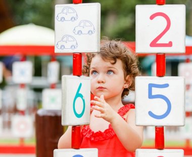 Küçük kız oyun alanında oynuyor.