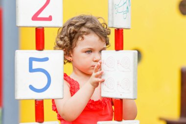 Küçük kız oyun alanında oynuyor.