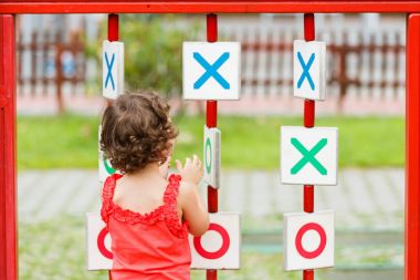 Küçük kız oyun alanında oynuyor.