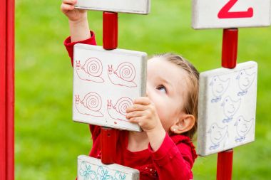 Küçük kız oyun alanında oynuyor.