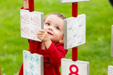 Küçük kız oyun alanında oynuyor.