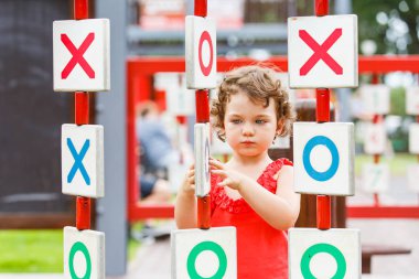 Küçük kız oyun alanında oynuyor.