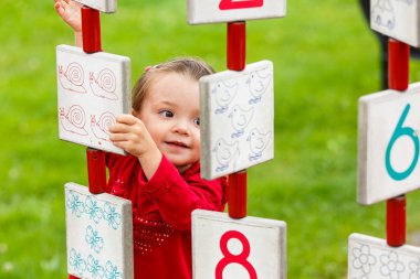 Küçük kız oyun alanında oynuyor.