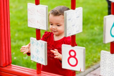 Küçük kız oyun alanında oynuyor.