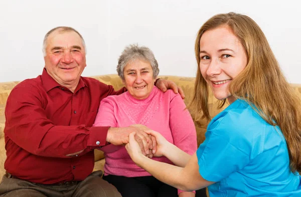 Gülümseyen yaşlı çift ve genç caregiver