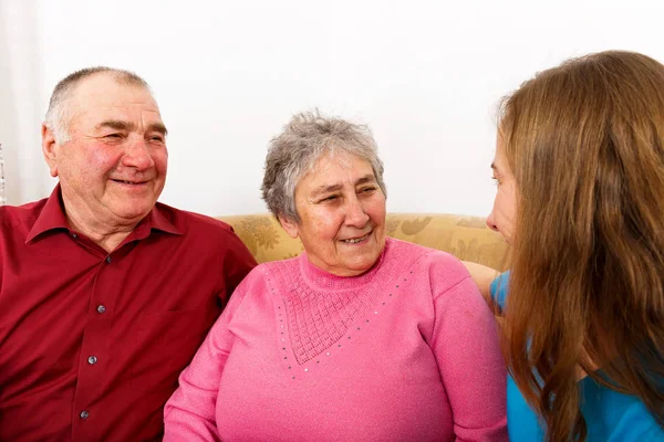 幸せな老夫婦と若い介護者 — ストック写真
