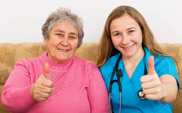 Ältere Frau und junge Pflegekraft — Stockfoto