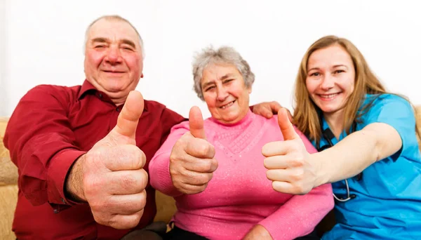 Felice coppia anziana e giovane caregiver — Foto Stock