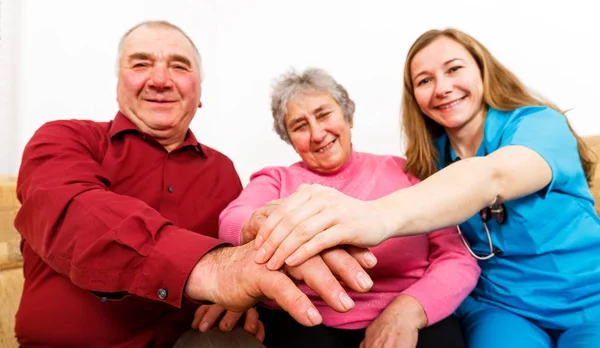 Gülümseyen yaşlı çift ve genç caregiver