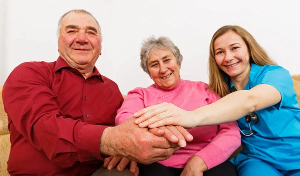 Gülümseyen yaşlı çift ve genç caregiver