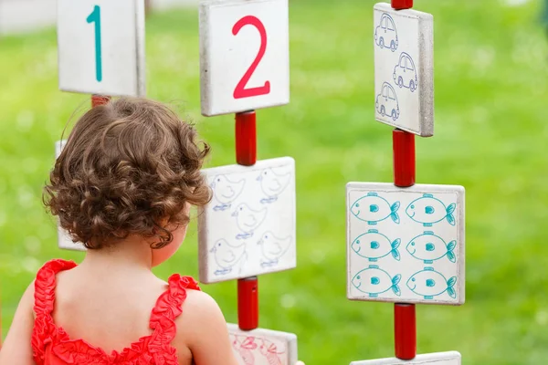 Küçük kız oyun alanında oynuyor.