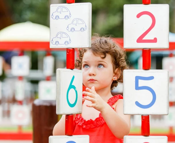 Küçük kız oyun alanında oynuyor.