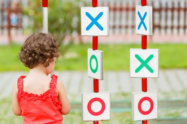 Küçük kız oyun alanında oynuyor.