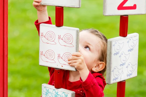 Küçük kız oyun alanında oynuyor.