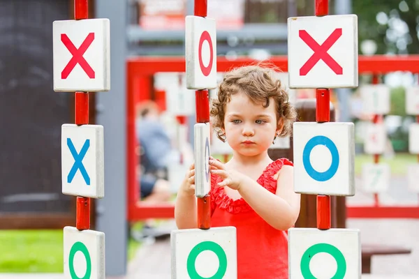 Küçük kız oyun alanında oynuyor.
