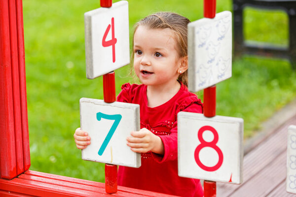 маленькая девочка играет на детской площадке