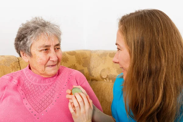 Happy elderly woman and young caregiver Stock Picture