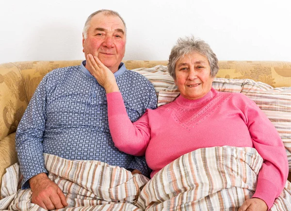 Äldre par sitter på sängen — Stockfoto
