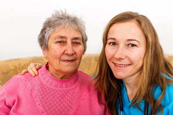 Feliz anciana y joven cuidadora — Foto de Stock