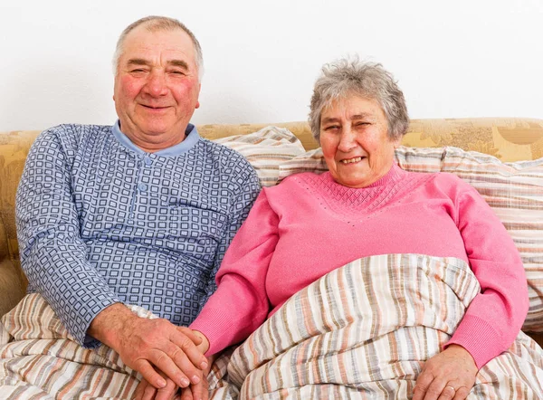 Elderly couple sitting on bed — Stock Photo, Image