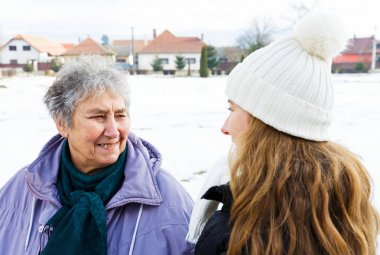 Gülümseyen yaşlı kadın ve genç caregiver