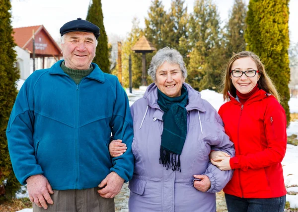 Elderly couple and young caregiver — Stock Photo, Image