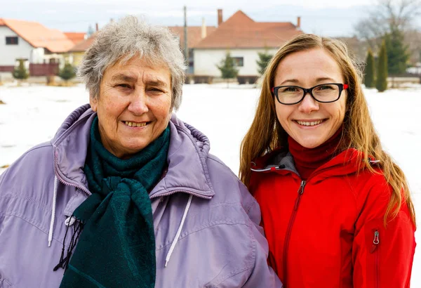 Gülümseyen yaşlı kadın ve genç caregiver