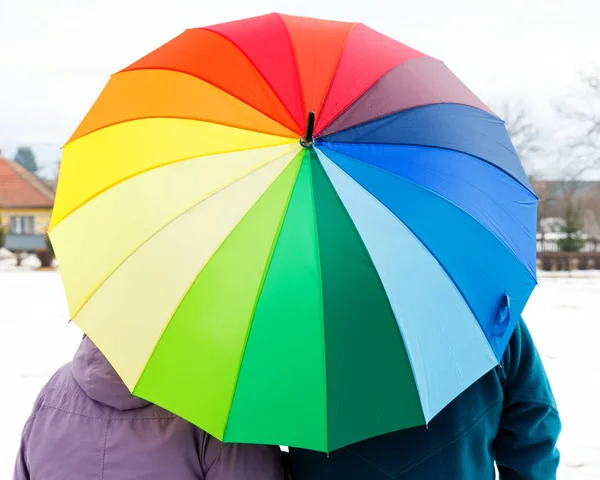 Elderly couple with colorful umbrella — Stock Photo, Image