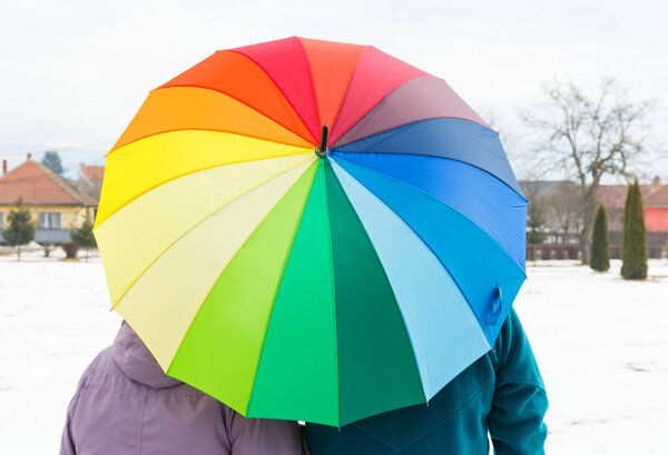 Пожилая пара с разноцветным зонтиком
