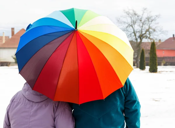 Älteres Ehepaar mit buntem Regenschirm Stockbild