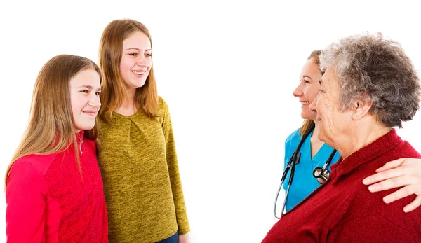 Пожилая женщина с внучками и молодым доктором — стоковое фото