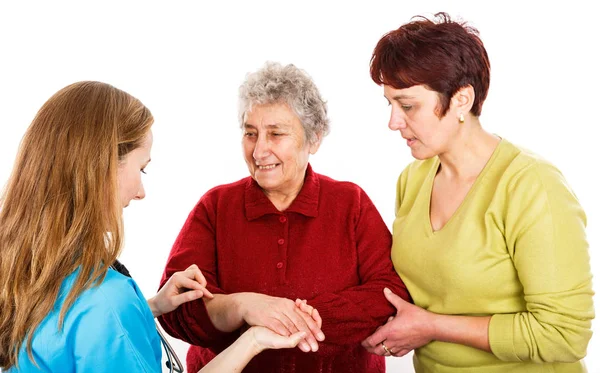 Elderly woman with carer and the young doctor — Stock Photo, Image