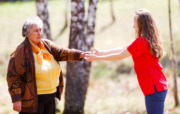 Elderly woman and young caregiver — Stock Photo, Image