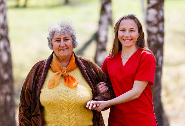 高齢の女性と若い介護者 — ストック写真