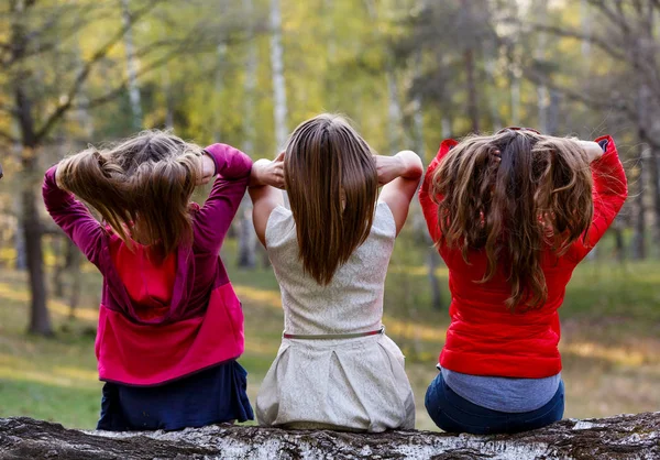 Jonge dames zittend op boomstronk in het bos — Stockfoto