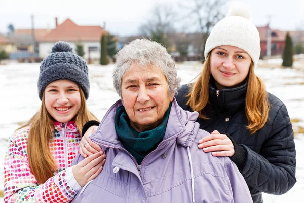Elderly woman and granddaughters — Stock Photo, Image