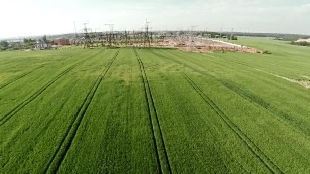 Subestação urbana. Linhas de energia e campo agrícola. Pôr do sol — Vídeo de Stock