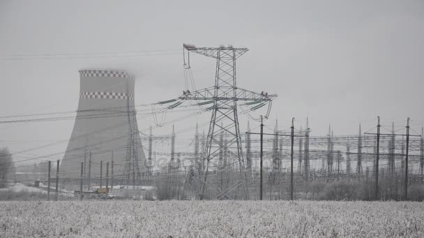 Elektrische leidingen in de sneeuw. Warmtekrachtkoppeling plant in een sterke sneeuwstorm — Stockvideo