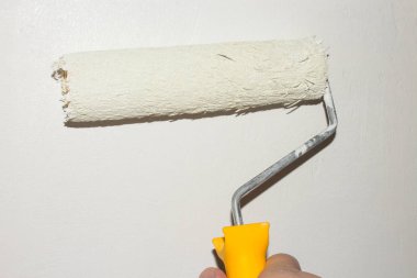 Duvarları beyaz boyayla boyuyor. İnsanlar silindirle boyuyor..