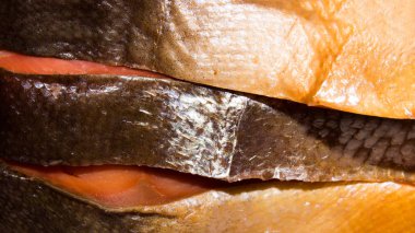 Kırmızı füme balık. Kırmızı balıkların arka planı. Kırmızı balıklar parçalara ayrılmış..