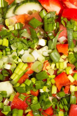 Sebzeler parçalara ayrılır. Domatesli salatalık, kırmızı biber ve yeşil soğan. Salata için sebze..