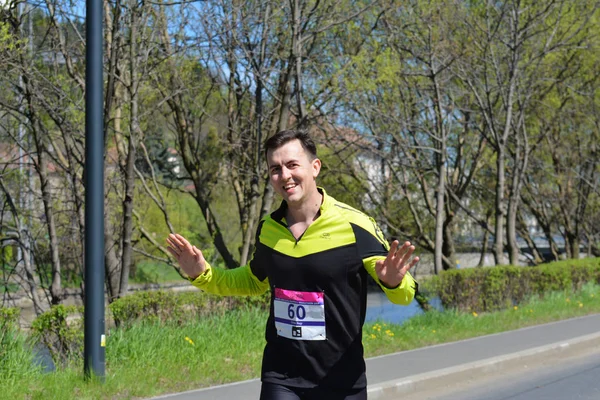 Jeune homme court souriant dans la rue — Photo