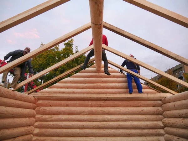 Carpenters assemble timber  frame with common rafters on cabin roof — Stock Photo, Image