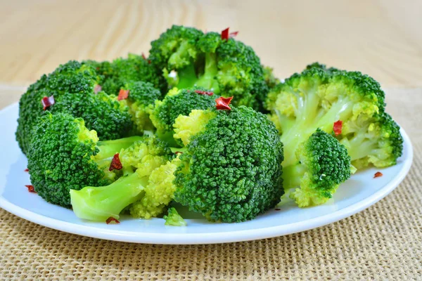 Steamed broccoli with red pepper flakes on plate