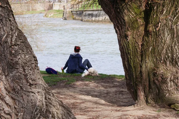 Ung kvinna och hennes hund koppla av nära floden — Stockfoto