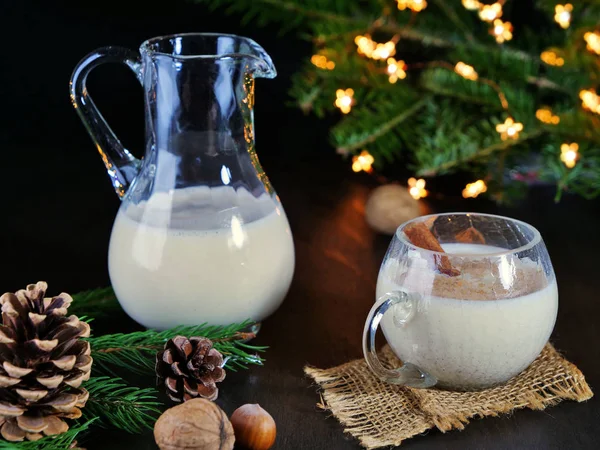 Oggnog em um jarro e vidro na mesa de Natal — Fotografia de Stock