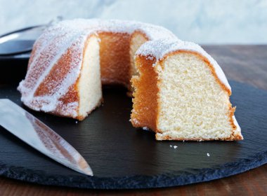 Vanilyalı kek dilimlenmiş, siyah tabakta gugelhupf.