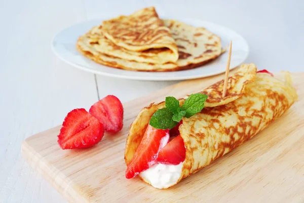 Coconut flour keto wraps with cottage cheese and strawberries. Low-carb gluten free crepe on cutting board, closeup — Stock Photo, Image