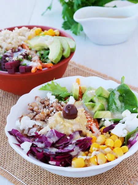 Deux bols de Bouddha avec des légumes, des grains sains et des protéines. Salade végétarienne saine avec bouillie de sarrasin, maïs, avocat et humus avec sauce tahini — Photo