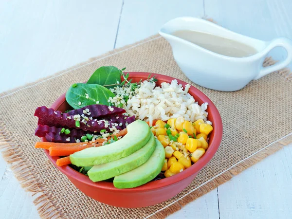 Prato de tigela com arroz integral, repolho vermelho, abacate, cenoura, espinafre e raiz de beterraba servida com molho tahini — Fotografia de Stock